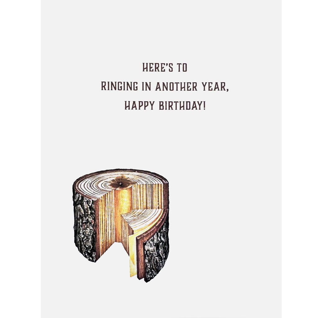 Tree stump cut away showing rings with greeting, Here's to ringing in another year. Happy Birthday.
